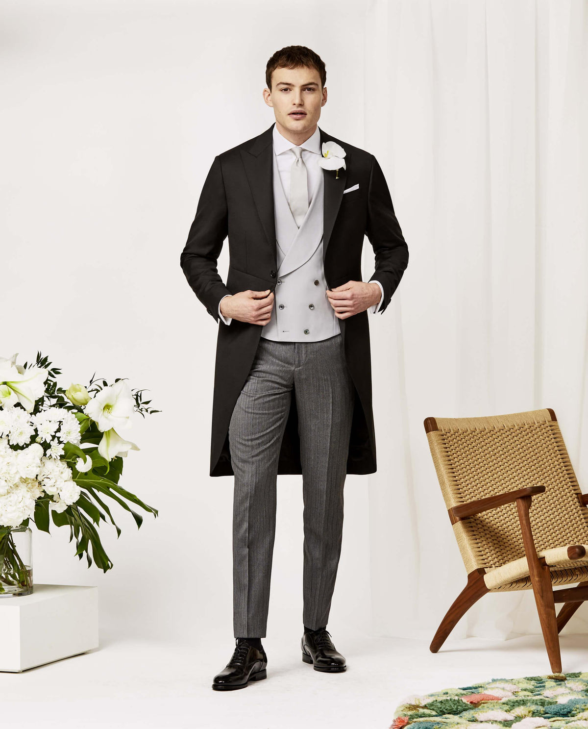 Traditional wedding black morning coat with silver double breasted vest, white shirt and charcoal striped pants