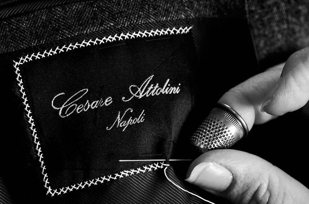 Cesare Attolini label being stitched by hand