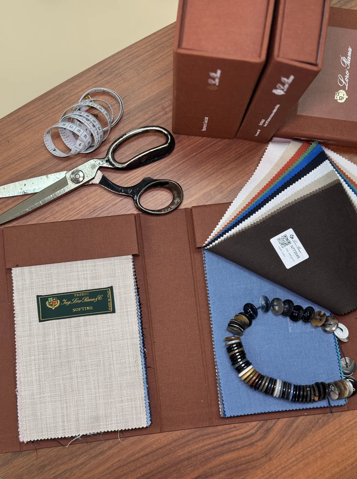 Fabric swatch book with scissors and tailoring tools on a table