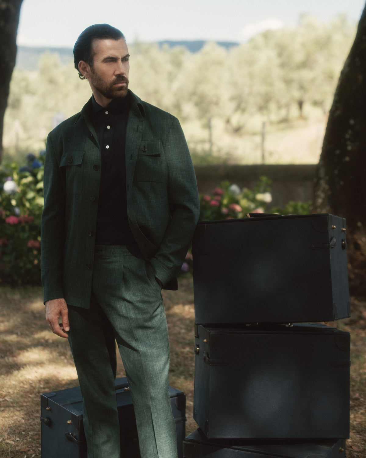 Galliani green overshirt suit with a black polo in an olive grove
