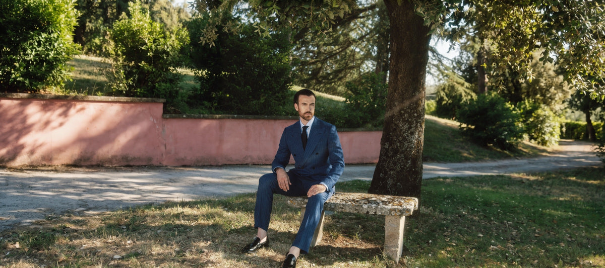 Galliani made to measure navy pinstripe double-breasted suit, seated in an Italian garden