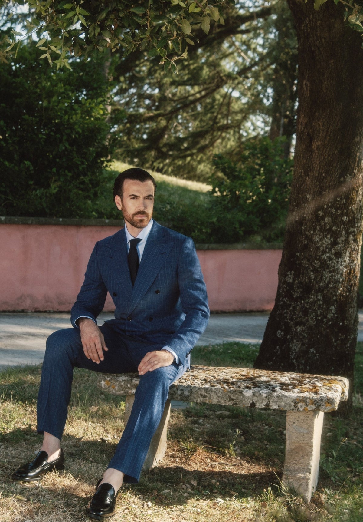 Galliani made to measure navy pinstripe double-breasted suit, seated in an Italian garden