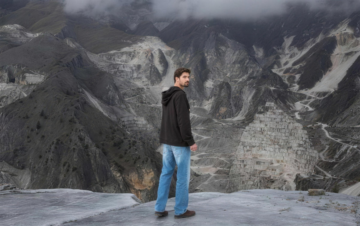 Man in a Marco Pescarolo hoodie and jeans above a marble quarry