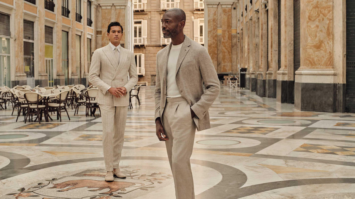 Two men in beige suits in a grand arcade