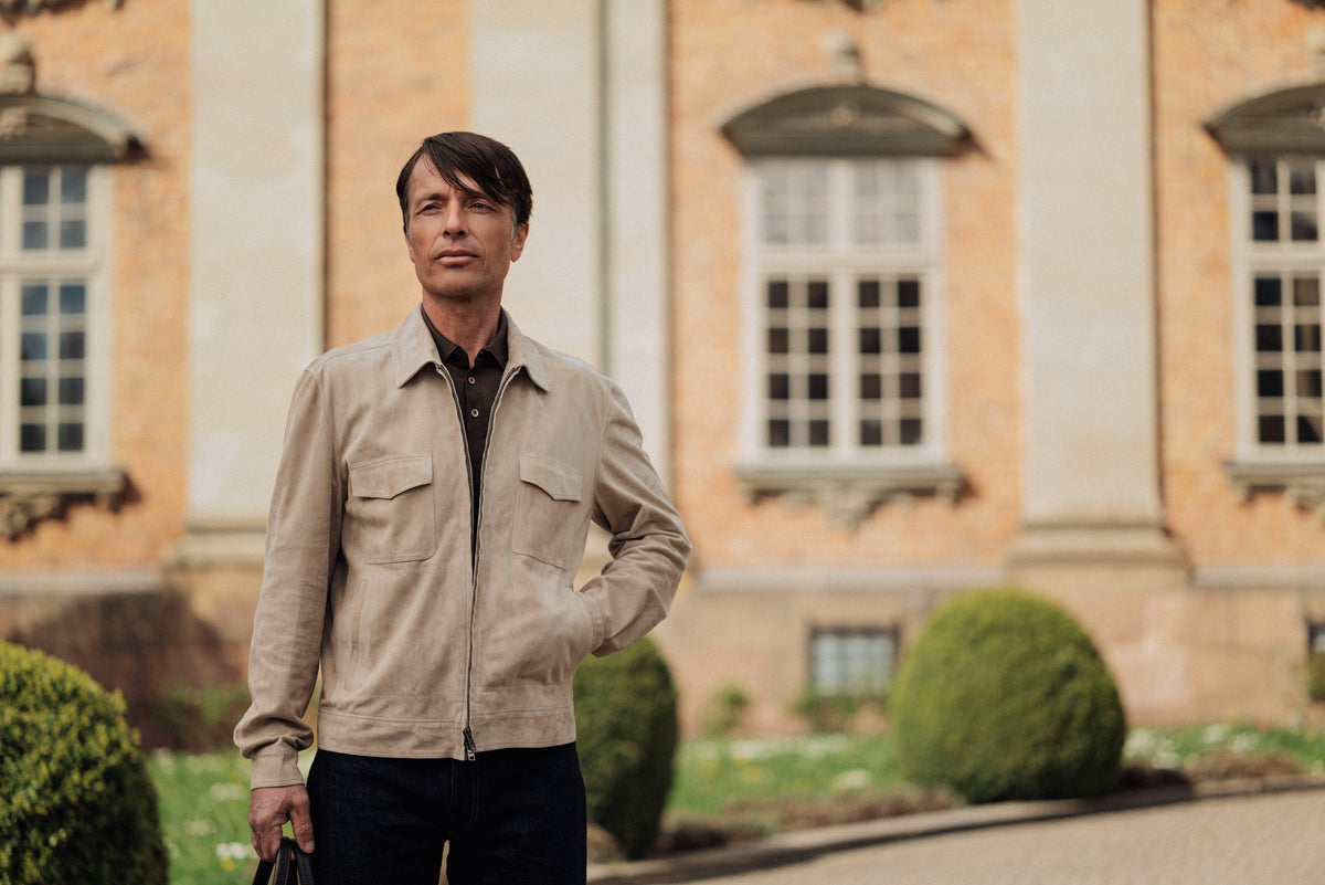 Man in Rifugio beige suede jacket outside a villa