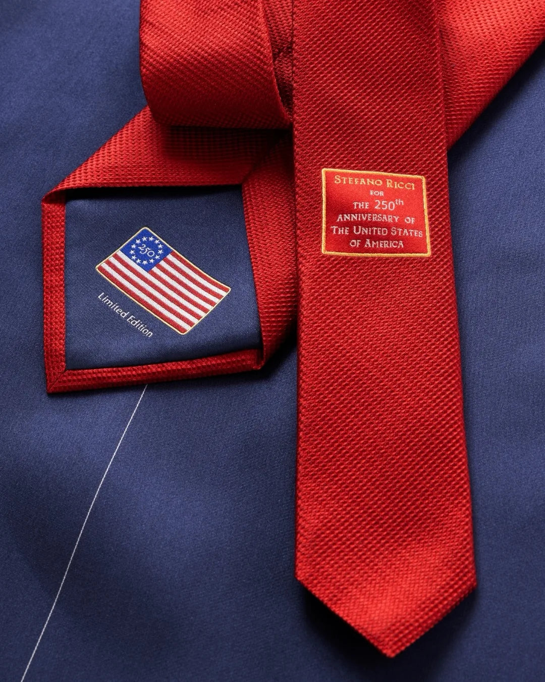 Red Stefano Ricci silk tie with an American flag lining on a navy suit.