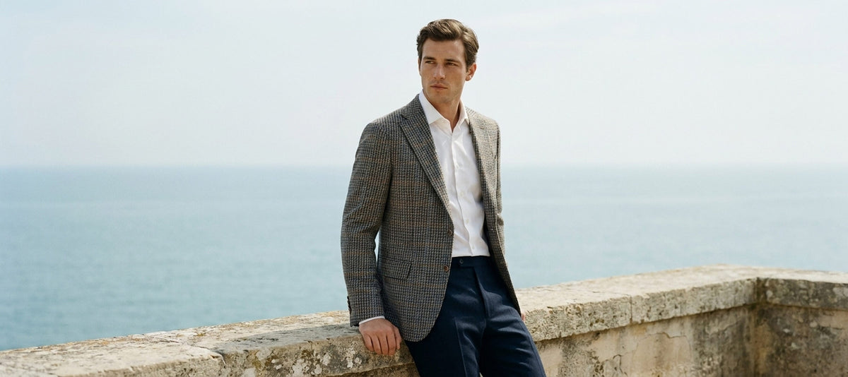 Man in Zanella trousers and gray jacket by the sea